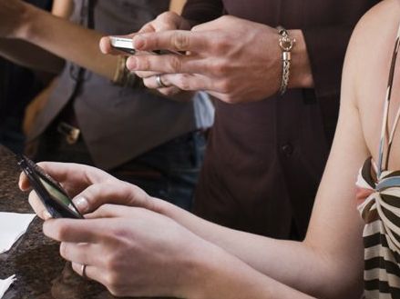 Friends texting at bar together Friends texting at bar together